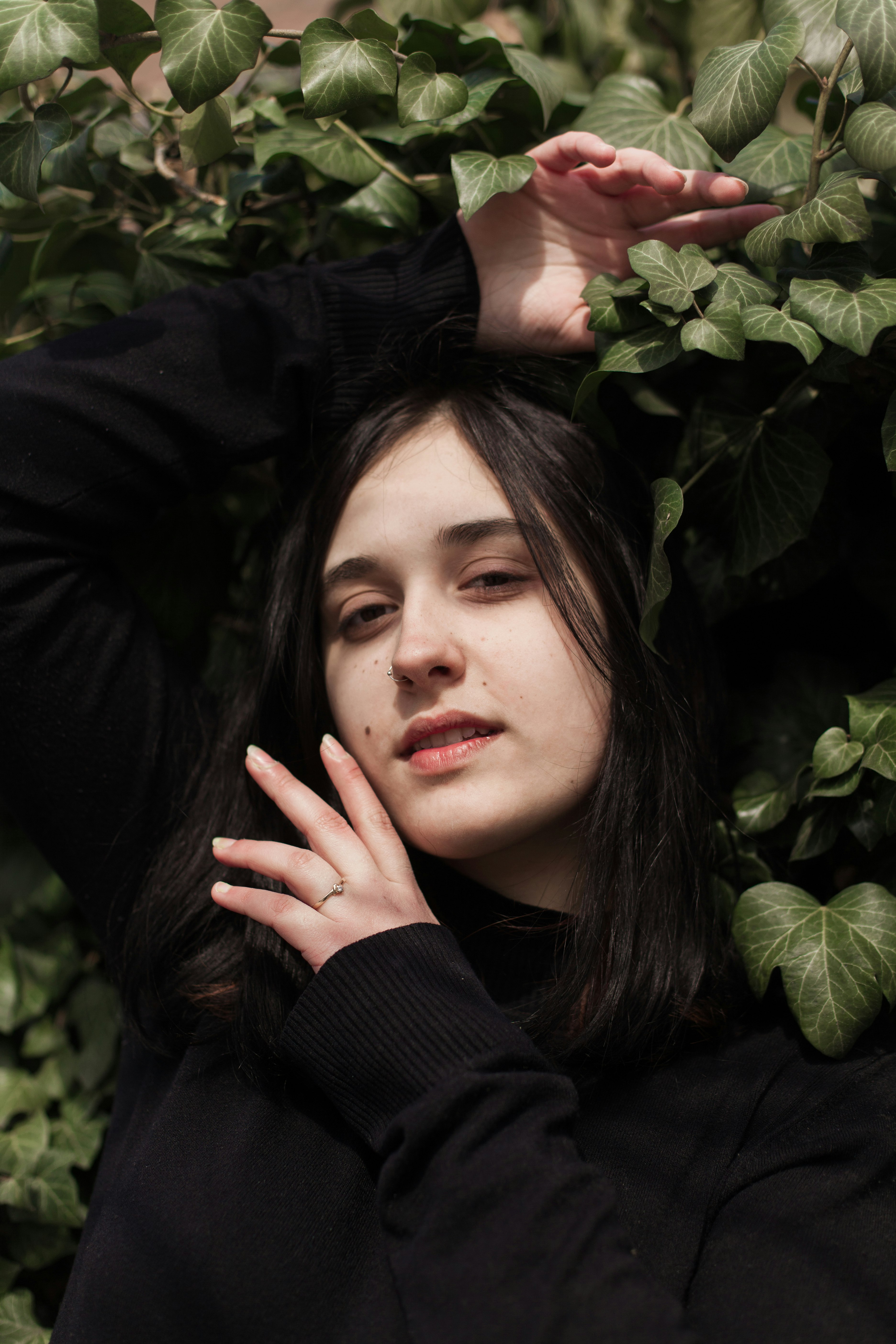 woman in black long sleeve shirt holding her face